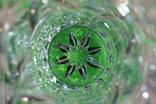 Macro abstract view of beautiful lead crystal glass texture with star burst pattern design, with green background