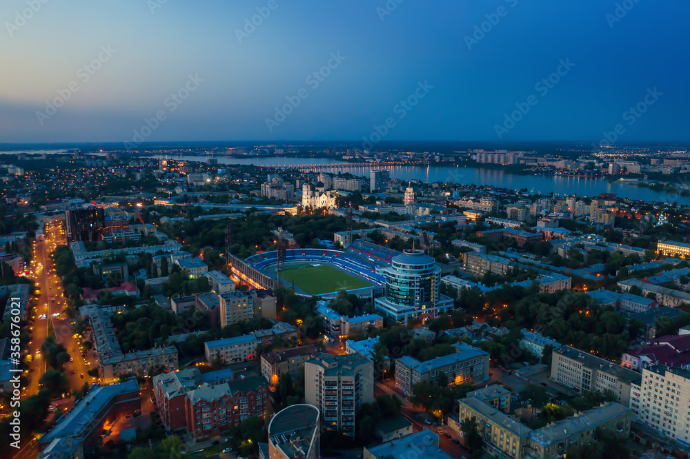 Obraz premium Voronezh city center in evening with stadium, roads and many buildings, aerial view.
