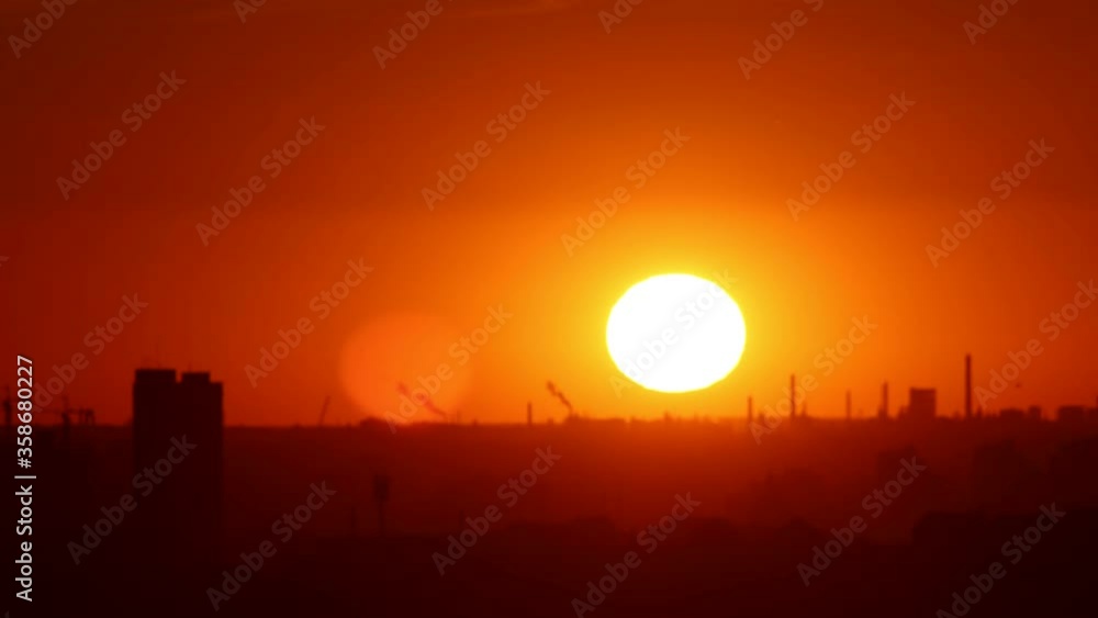 Bright orange sunlight shines on the city and the sun goes down on the sunset - industrial construction site Bright orange sunlight shines on the city and the sun goes down on the sunset - industrial construction site