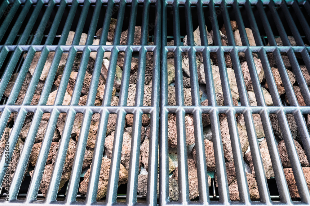 Obraz premium New and clean barbecue grill with lava rocks for gas cooking.