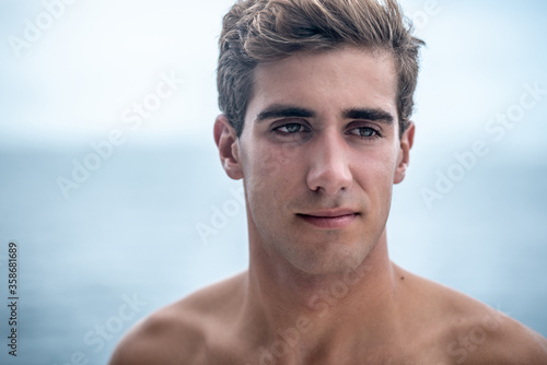 Portrait of young man smile, surfer and blue ocean on background