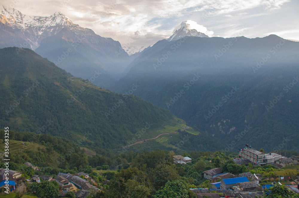 The peaks of the mountains of Nepal among the trees are the landscape of the Himalayas
