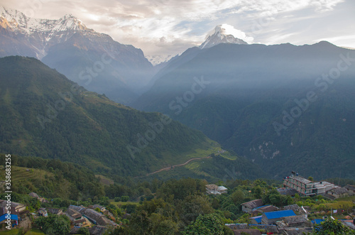 The peaks of the mountains of Nepal among the trees are the landscape of the Himalayas 