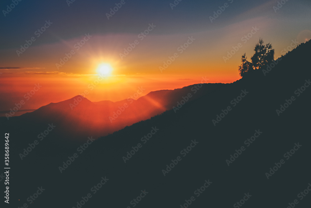 Beautiful landscape of Mount Rinjani at sunrise. Backlight silhouette sunrise over the mountain in Lombok Island, Indonesia