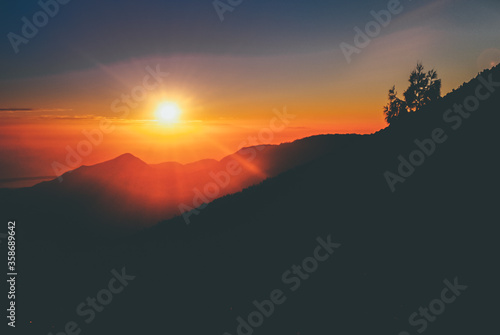 Beautiful landscape of Mount Rinjani at sunrise. Backlight silhouette sunrise over the mountain in Lombok Island, Indonesia © Harry