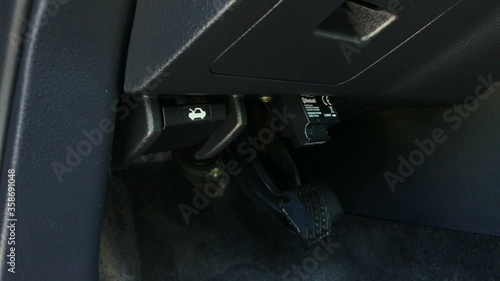 OBD2 car scanner tool plug into diagnostic port under steering wheel dashboard. photo