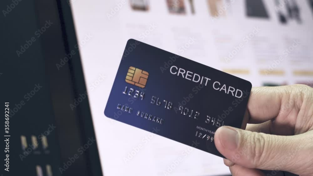 4K Video pan shot hand hold credit card in front of eCommerce website in monitor. Video concept for online shopping and payment. 4K Video pan shot hand hold credit card in front of eCommerce website in monitor. Video concept for online shopping and payment.