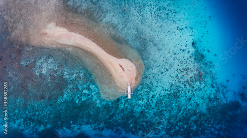 Top view of small sandy island in Takat Sagele, Moyo Island, Sumbawa, Indonesia. Small beautiful island with white sandy beach and a boat