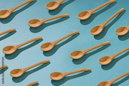 Background of a large number of wooden spoons on a blue background.