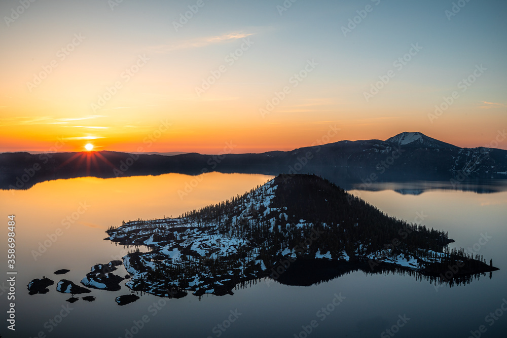 Crater lake sunset with sunburst. 