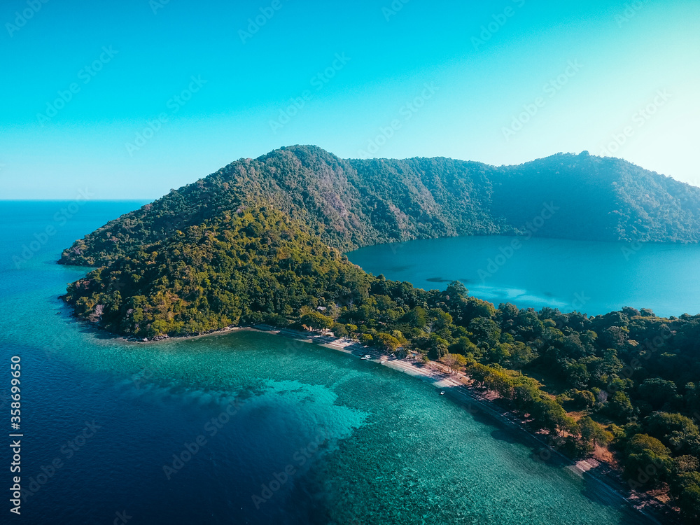 Aerial view of Satonda Island, Indonesia. The idyllic volcanic island of Satonda is fringed by coral reef in Indonesia. This tropical area is found in the geologically active ring of fire