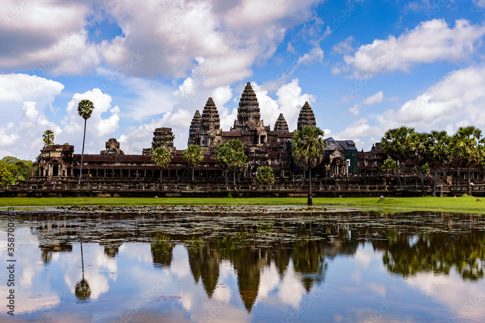 It's Angkor Wat (Temple City) and its reflection in the lake, a Buddhist, temple complex in Cambodia and the largest religious monument in the world. View from the garden It's Angkor Wat (Temple City) and its reflection in the lake, a Buddhist, temple complex in Cambodia and the largest religious monument in the world. View from the garden