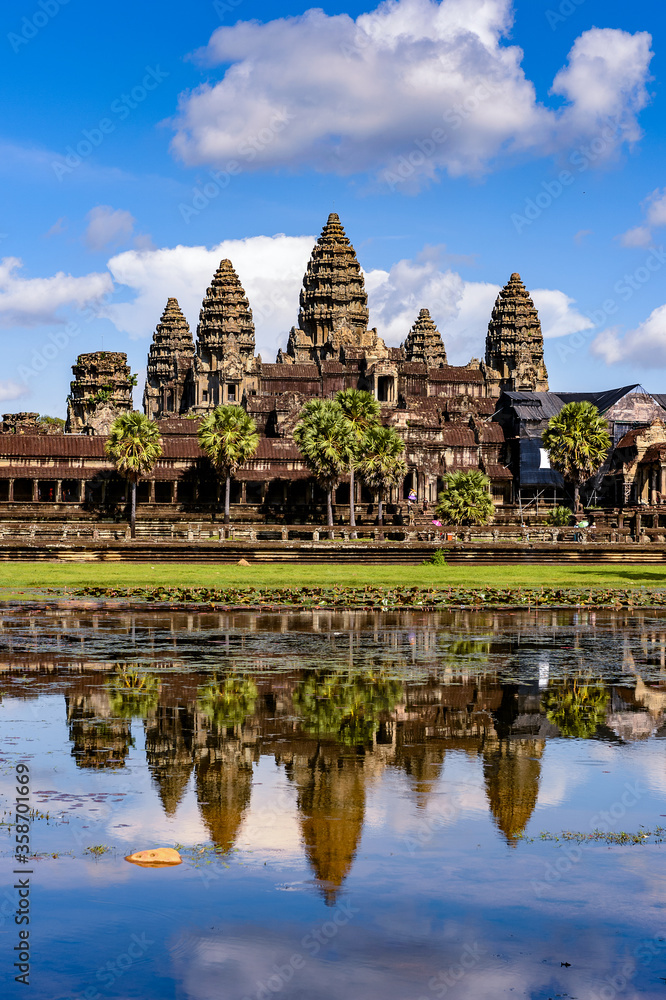 Naklejka premium It's Angkor Wat (Temple City) and its reflection in the lake, a Buddhist, temple complex in Cambodia and the largest religious monument in the world. View from the garden