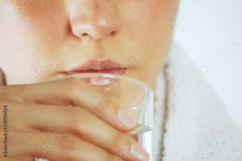 Woman holding glass of water against white background