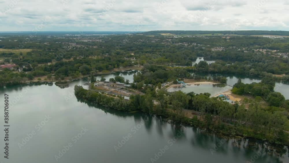 Paradise park of Cergy in France with beautiful lakes surrounded by tall green trees on a cloudy day in spring Paradise park of Cergy in France with beautiful lakes surrounded by tall green trees on a cloudy day in spring