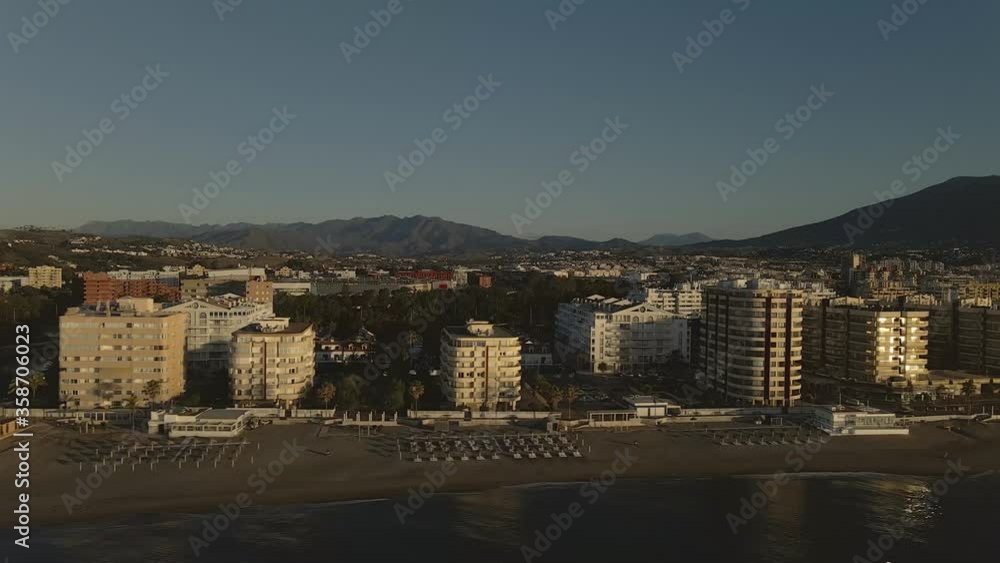 Aerial coastal beachfront Spanish Malaga resorts apartments along shoreline panning right Aerial coastal beachfront Spanish Malaga resorts apartments along shoreline panning right