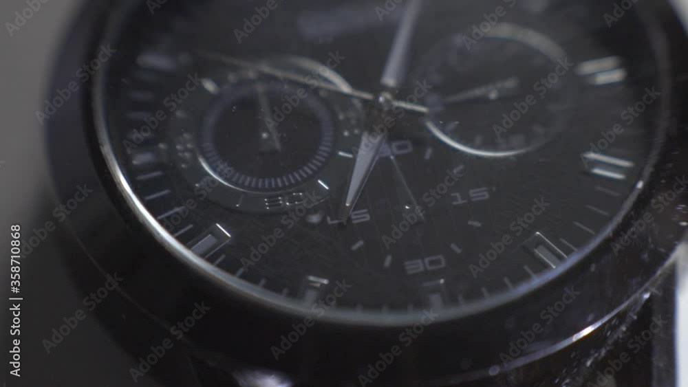Light Reflecting On The Glass And Steel Frame Of A Black Wristwatch - close up Light Reflecting On The Glass And Steel Frame Of A Black Wristwatch - close up