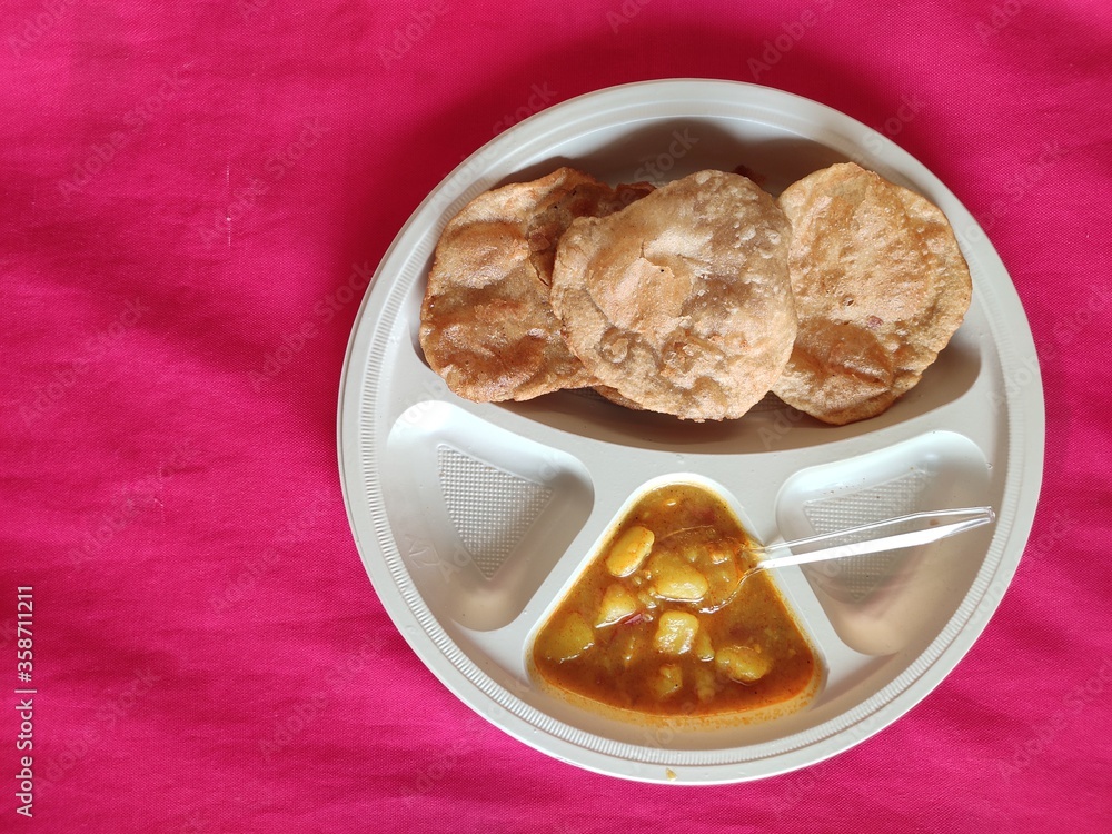 Puri and Potato Curry aalu sabji - an indian cuisine in round plate. Puri and Potato Curry aalu sabji - an indian cuisine in round plate.