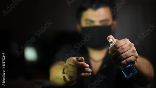 young man using sanitizer hand wash wear mask clothe in black background in corona virus pandemic work from home during covid 19