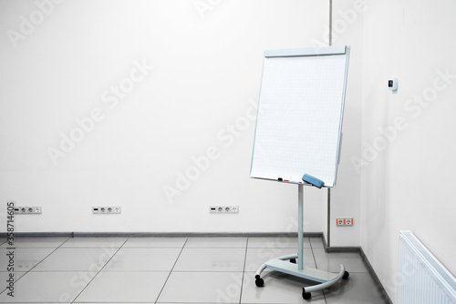 empty flipchard board with marker and sponge in a meeting room. conducting seminars and lectures. training. coach