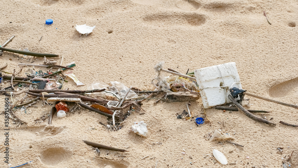 Obraz premium Environmental pollution. Ecological problem. Garbages, plastic, and wastes on the sandy beach of tropical sea.