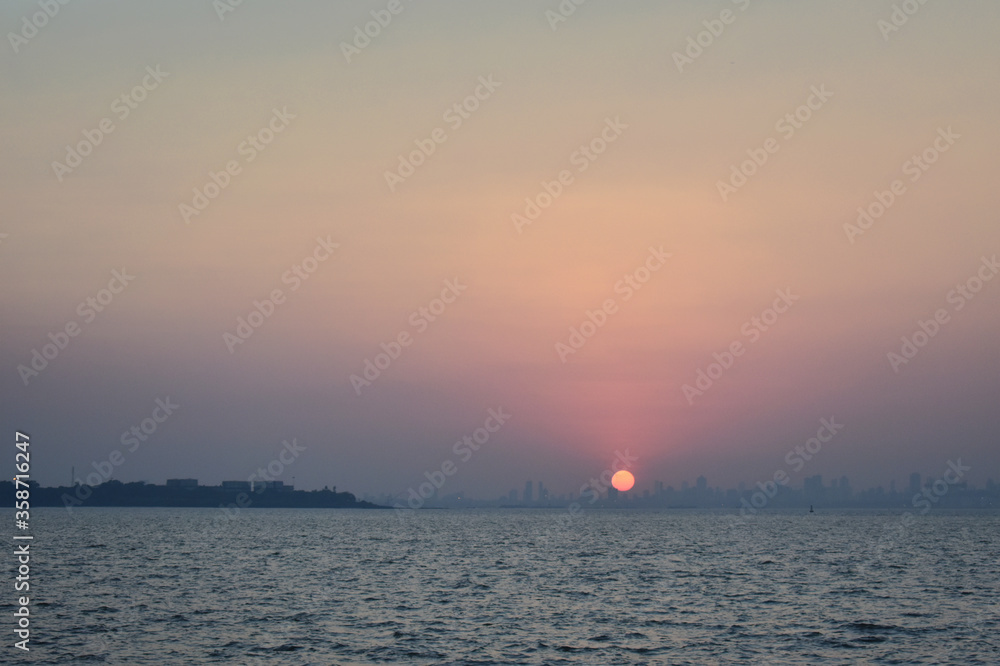 Sun is setting behind the huge buildings near Mumbai shore. Sun is setting behind the huge buildings near Mumbai shore.