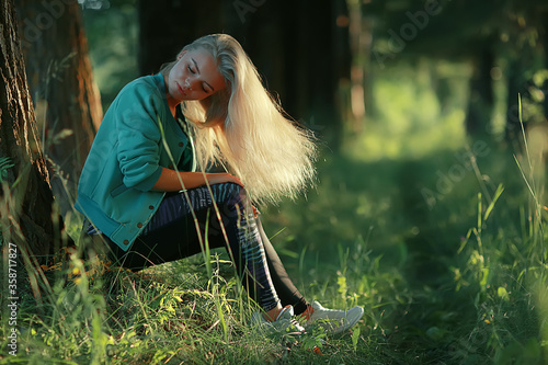 blonde long hair nature summer / happy adult girl with developing in the wind long blonde hair in the summer field