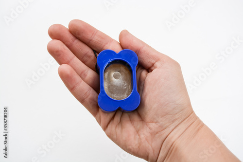 Obraz na plátně Blue plastic bone shape clicker tool for dog training in arm isolated on white b