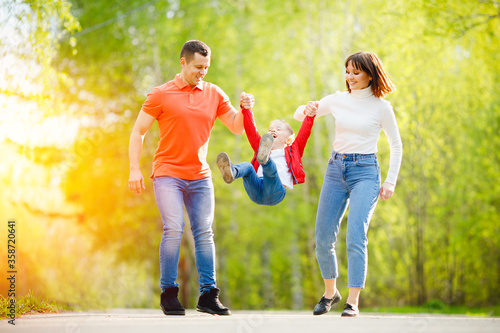 Happy Caucasian family parents and children on vacation playing together outdoor park, sunlight © Parilov