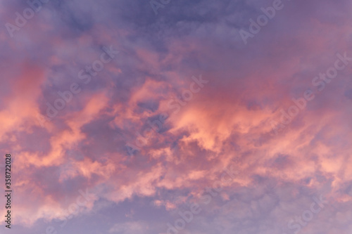 Dramatic pink sunset in the cloudy sky. Space for text. Background. Blurred.