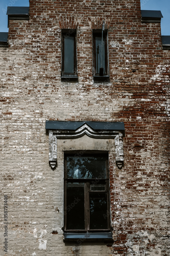 Old brick wall with beautiful windows on an abandoned building