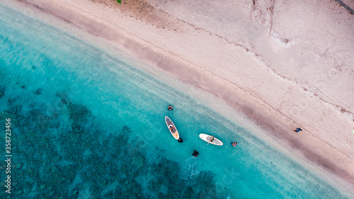 Aerial drone birds eye view of tourists canoeing in tropical beach of Moyo Island, Sumbawa, Indonesia photo