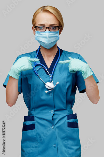 medical doctor nurse woman with stethoscope wearing protective mask and rubber or latex gloves showing at herself