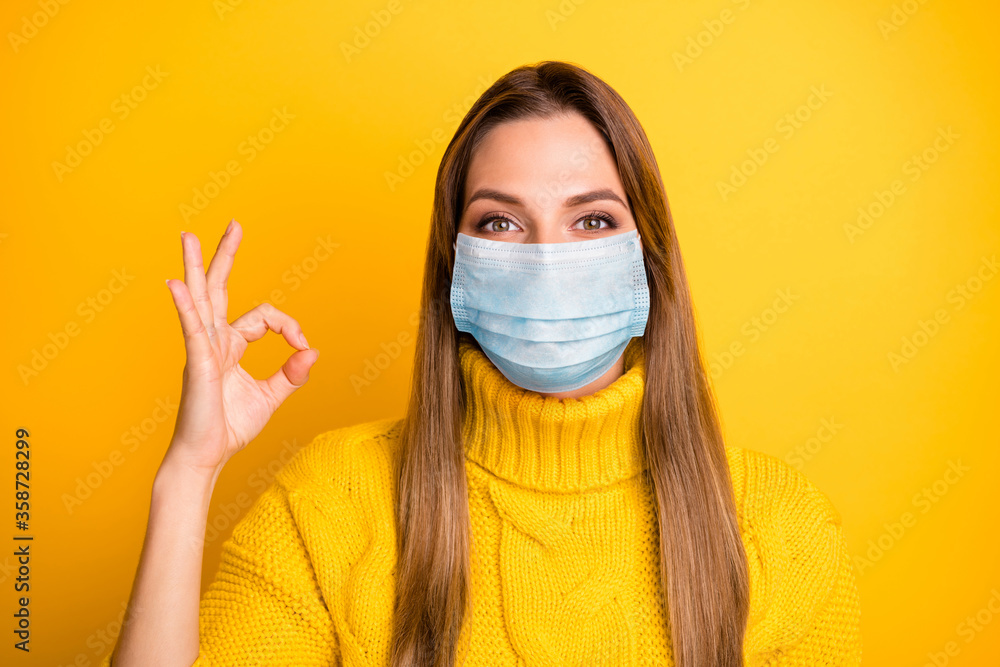 Close-up portrait of her she nice attractive girl wearing safety gauze mask showing ok-sign stop respiratory pneumonia influenza mers cov isolated over bright yellow color background Close-up portrait of her she nice attractive girl wearing safety gauze mask showing ok-sign stop respiratory pneumonia influenza mers cov isolated over bright yellow color background