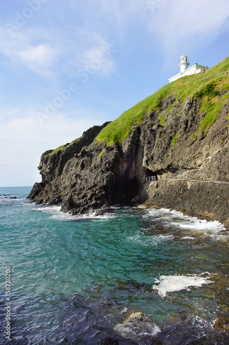 日本海の断崖の上に立つ白い灯台