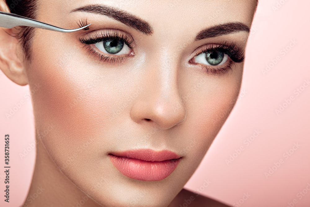 Fototapeta premium Beautiful Woman with Extreme Long False Eyelashes. Eyelash Extensions. Makeup, Cosmetics. Beauty, Skincare. Woman Glues Eyelashes