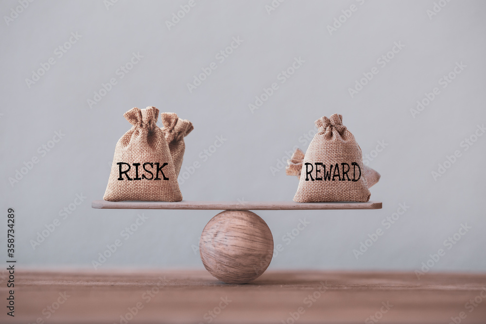 Risk and reward bags on a basic balance scale in equal position. risk