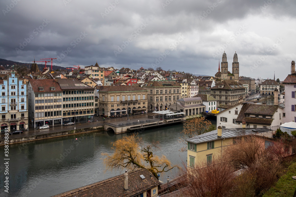 Obraz premium Zurich old town at cloudy winter sky. Cityscape from above with beautiful street.Switzerland landscape before sunset in rainy season. Slow speed shutter.