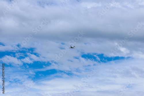 Blue sky and airplane through the clouds