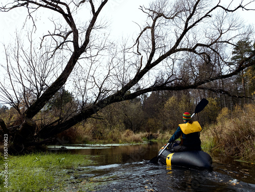 River rafting in the fall. A young man rafts in a boat on a river in the wild. Packrafting in wilderness. photo