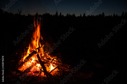 Warm bright bonfire / fireplace on the summer / spring night at the polish lake in the forest