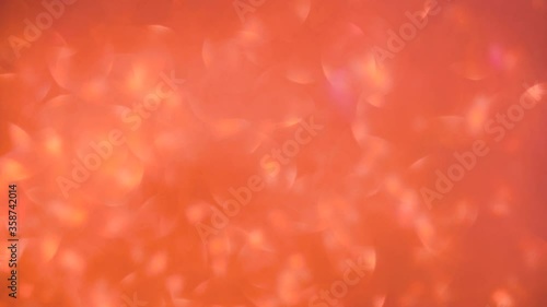 Orange glitter in selective focus. Abstract art, small circular motion of light