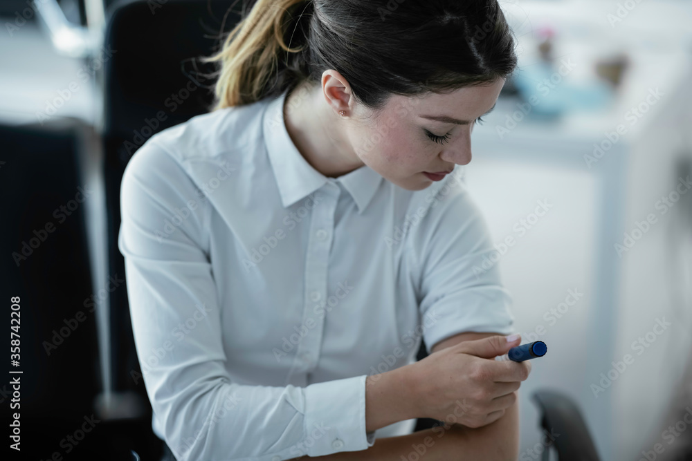 Businesswoman giving herself an injection of insulin. Businesswoman giving herself an injection of insulin.