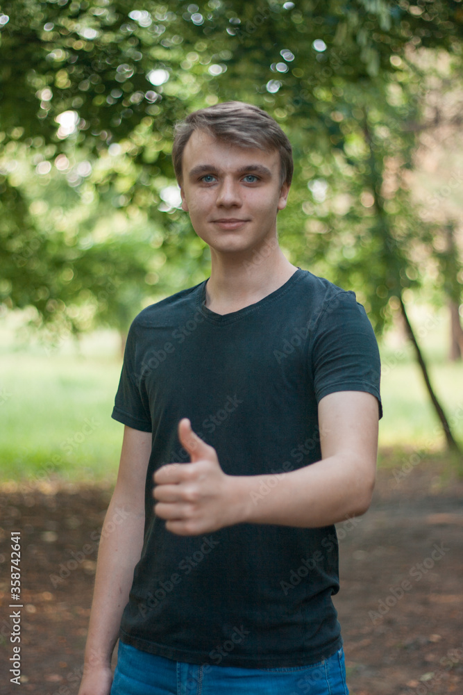 Happy young man gives a thumbs up and looks at the camera Happy young man gives a thumbs up and looks at the camera