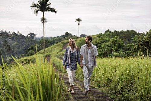 Asia, Indonesia, Bali, young Caucasian couple, wearing smart casual clothing, enjoying a walk along the famous Campuan ridge, one of the well known tourist attractions in Ubud. 