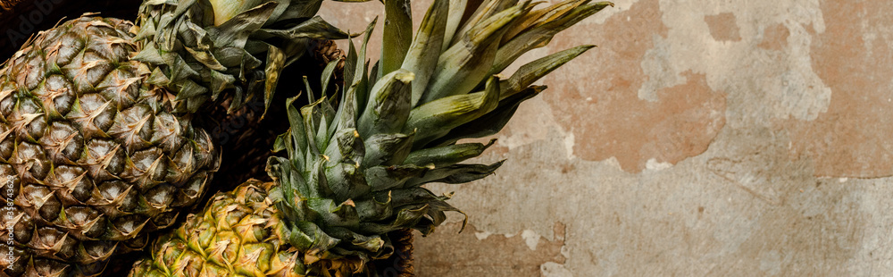 top view of ripe exotic pineapples on weathered surface, panoramic crop - obrazy, fototapety, plakaty 