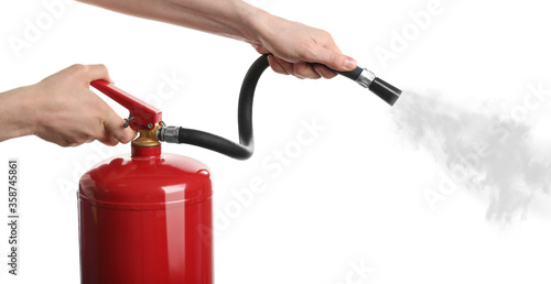Woman using fire extinguisher on white background, closeup photo