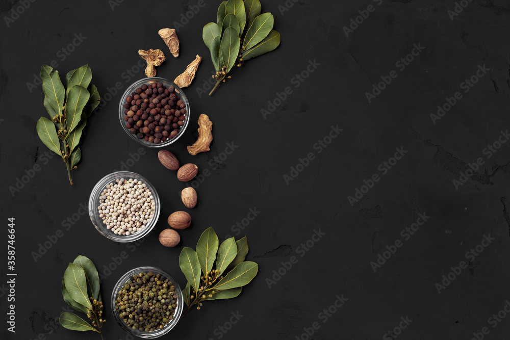 Bowls with assorted spices on dark background