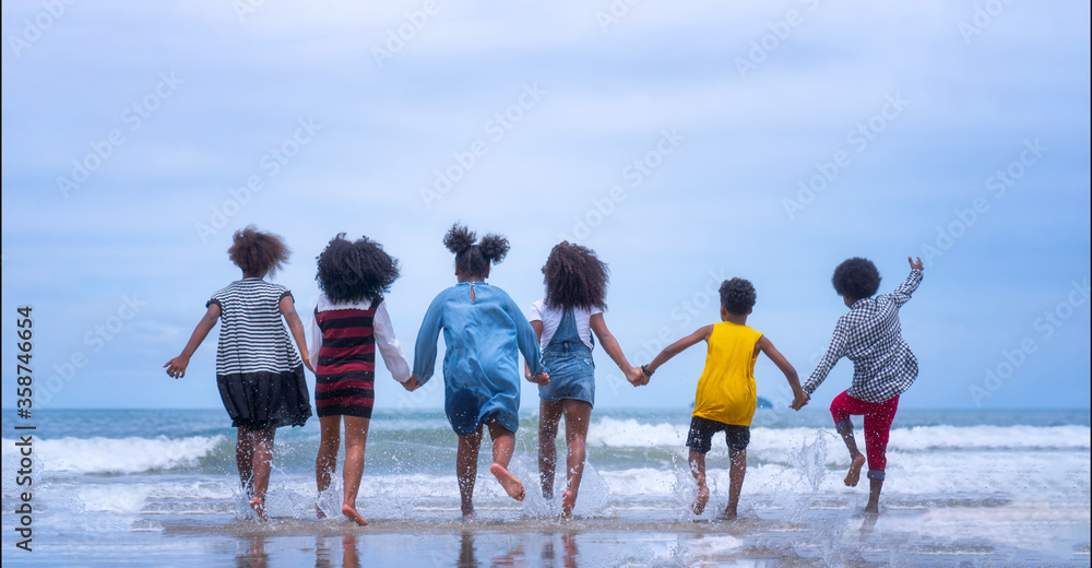 Group Of Young African American Children Running  on the beach.
