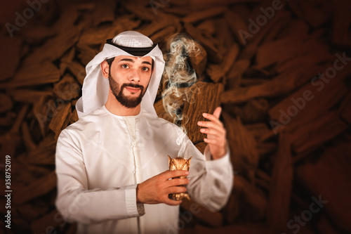 Arab man holding Bakhour holder celebrating the holy month of Ramadan Kareem, Arabic Bakhour advertising photo